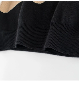 Close-up of black and khaki knitted sweater with ribbed hem and fine stitch detail