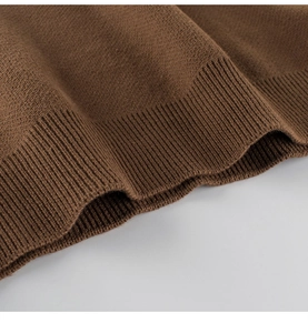 Close-up of brown knit sweater texture showing high-quality ribbed hem and soft fabric