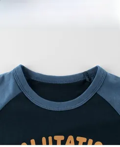 Détail du col rond contrasté et des coutures sur un t-shirt en coton pour enfants