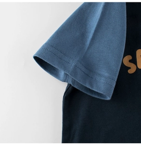 Gros plan sur les coutures contrastées de la manche bleue et le coton du t-shirt enfant