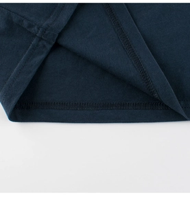 Vue macro détaillée de la double couture de haute qualité sur l'ourlet du T-shirt bleu marine
