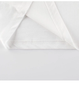 Détail de la double couture et de la texture en coton doux sur le t-shirt blanc dinosaure