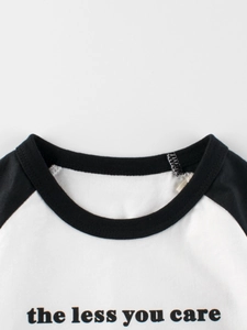 Toddler boys black and white raglan sleeve t-shirt with 'the less you care' slogan print