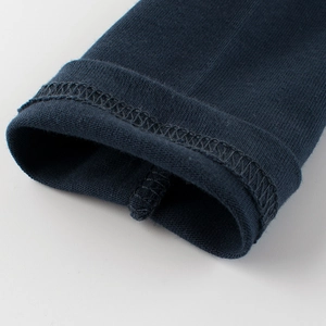 Gros plan sur les coutures doubles de qualité sur ce t-shirt enfant bleu marine à manches