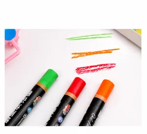Detailopname van cilindrische oliepastels in groene, rode en oranje kleuren