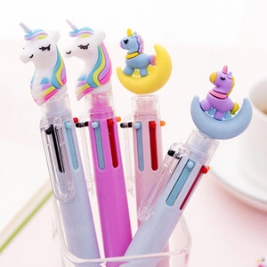 Détail de stylos licorne multicolores rose et violet dans un verre avec lumière douce