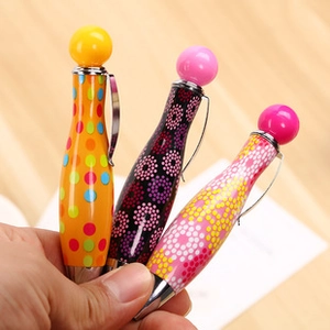 Gros plan de stylos gel créatifs en forme de quille de bowling sur un bureau en bois