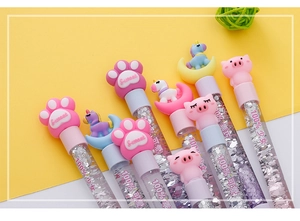 Détail de stylos à paillettes liquides avec figurines de pattes de chat et de licorne