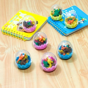 Detailed view of colorful dinosaur egg erasers set on a wooden desk with books
