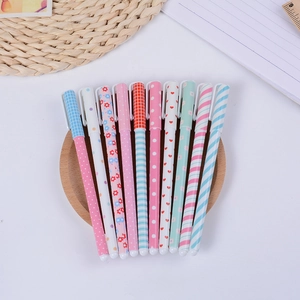 Lot de 10 stylos à gel colorés aux motifs variés sur un plateau rond en bois