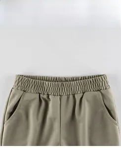 Detail view of elastic waist with side pockets on olive green lightweight kids pants