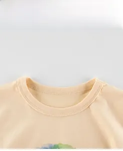 Détail de l'encolure en coton côtelé et des coutures de précision sur un t-shirt jaune enfant