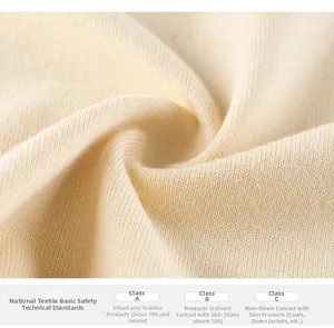 Gros plan sur un tricot en coton crème montrant la texture et les normes de sécurité textile