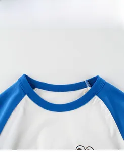 Détail du col rond côtelé et des coutures de manches raglan sur un t-shirt en coton enfant