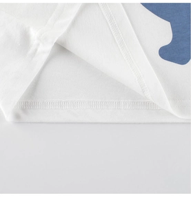 Détail de l'ourlet du t-shirt montrant des coutures propres et un tissu en coton de qualité