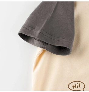 Détail des manches raglan bicolores et de l'imprimé 'Hi!' sur un t-shirt enfant en coton
