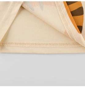 Détail de l'ourlet en coton doux avec couture double aiguille et rayures de tigre orange