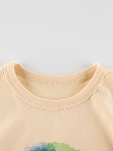 Gros plan du col rond et des coutures doubles sur le t-shirt beige pour enfants