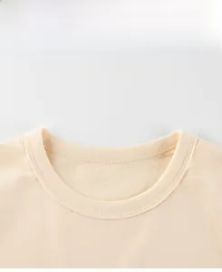 Detailed macro view of the ribbed crew neck and double stitching on boys dinosaur t-shirt