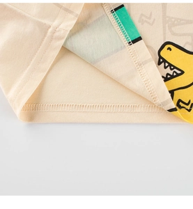 Detail of boys cotton T-shirt hem with cartoon dinosaur print and double-needle stitching