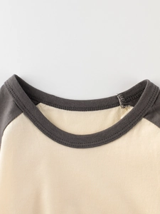 Gros plan sur t-shirt enfant manches raglan avec col rond côtelé en gris et beige