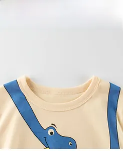 Detail of soft cotton crew neck collar on yellow kids t-shirt with blue dinosaur print