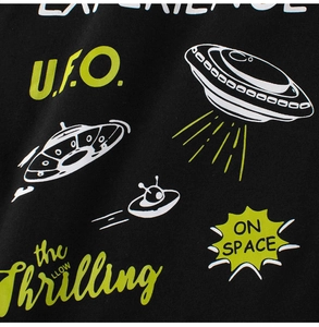 Macro detail of cartoon UFO print on black cotton kids T-shirt with neon green accents