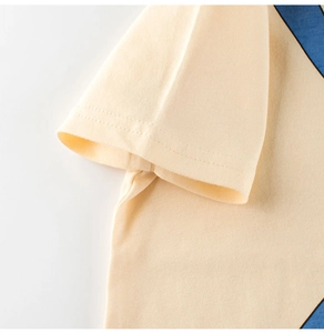 Close-up of sleeve stitching and fabric texture on a yellow cotton cartoon T-shirt