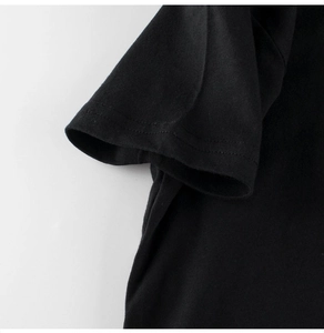 Detailed close-up of double-needle stitching on the black cotton T-shirt sleeve
