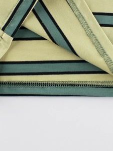 Close-up of bottom hem with yellow and blue stripes on boys cotton t-shirt