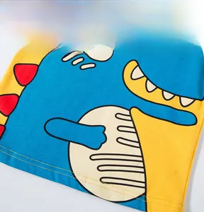 Détail d'un t-shirt enfant en coton jaune avec imprimé dinosaure bleu dessin animé