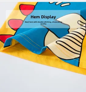 Détail de l'ourlet d'un t-shirt en coton avec coutures jaune et bleu et motif rouge