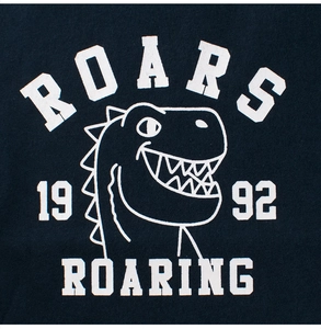 Close-up of white dinosaur screen print and ROARS lettering on kids' cotton navy t-shirt