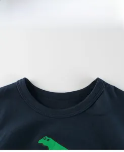 Close-up of ribbed crew neck and green dinosaur print on navy blue cotton kids t-shirt