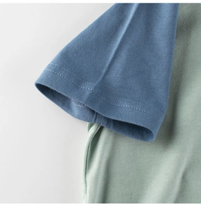 Détail des manches patchwork bleues et vertes montrant les coutures du t-shirt coton
