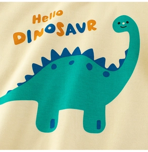 Dettaglio di una maglietta per neonati con dinosauro cartone animato e morbido tessuto beige