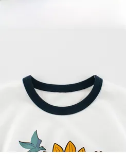 Détail du col rond contrasté avec coutures précises sur le t-shirt blanc pour enfants