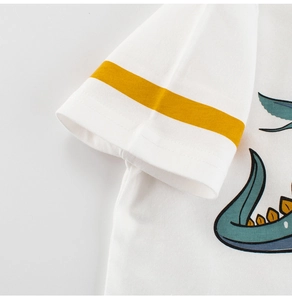 Détail de manche de t-shirt blanc en coton avec rayures jaunes et motif dinosaure