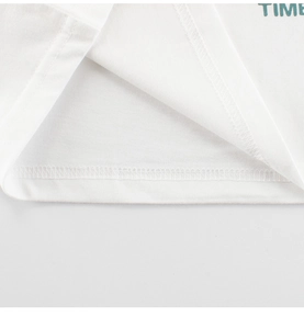 Détail de l'ourlet à double aiguille et du coton doux sur le t-shirt dinosaure pour garçon