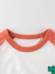 Short-sleeved cotton kids T-shirt with orange raglan sleeves and dinosaur print