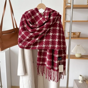 Detail of red and white checkered cashmere-style scarf with soft fringe tassels