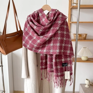 Detail of dark red plaid scarf showing soft cashmere-like texture and tassel fringe