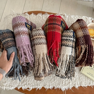 Vue détaillée de diverses écharpes à carreaux colorées avec franges et étiquettes