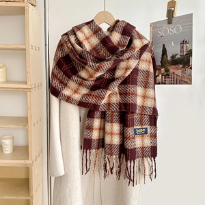 Écharpe à carreaux classique avec franges en bordeaux et orange sur manteau beige