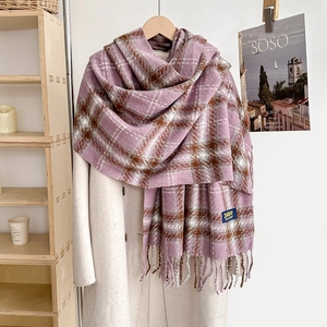 Détail d'une écharpe à carreaux rose et violette avec franges sur un manteau blanc élégant