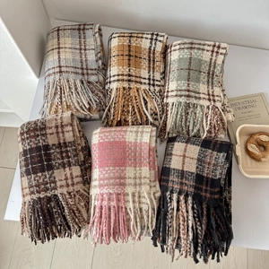 Close-up showing six various plaid patterns and soft fringe detail on winter scarves