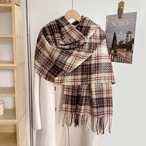 Plaid cashmere feel scarf in brown and beige with tassels on a white coat display