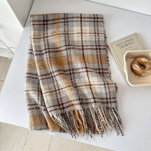 Detail of soft plaid scarf with fringe edge, gray and mustard yellow woven texture