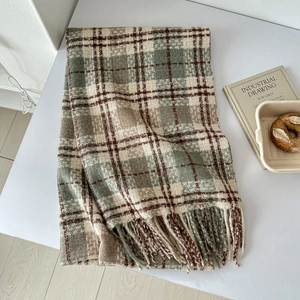 Detailed view of soft plaid scarf with tassels in earth tones and knit cashmere texture
