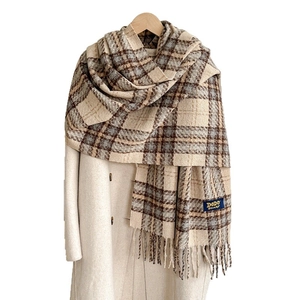 Écharpe à carreaux épaisse et chaude avec franges style rétro sur un manteau beige